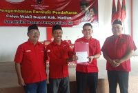 Ketua BMI Kabupaten Madiun Shandika Ratna Ferryantiko (dua dari kanan) dan jajaran pengurus DPC PDIP Kabupaten Madiun menunjukkan berkas pendaftaran kandidat Bacawabup Madiun, Sabtu (18/5/2024). Foto: Neumedia.id/Bormanto  