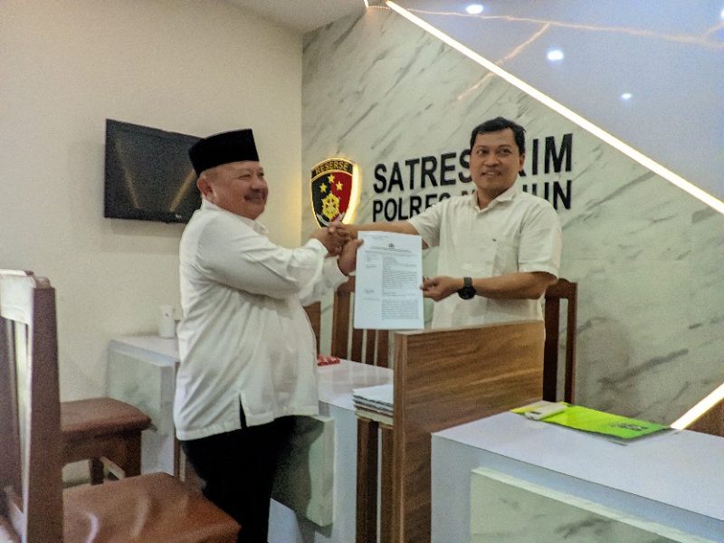 Ketua DPC PKB Kabupaten Madiun, Muhtarom (pakai peci) menunjukkan bukti pelaporan Lukman Edy di Satreskrim Polres Madiun, Senin (12/8/2024)