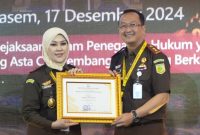 Kajari Kabupaten Madiun Oktario Hartawan Achmad menerima piagam penghargaan yang diserahkan oleh Kejati Jatim Mia Amiati. Foto : Instagram Kejari Kabupaten Madiun 