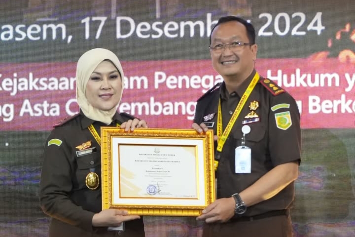 Kajari Kabupaten Madiun Oktario Hartawan Achmad menerima piagam penghargaan yang diserahkan oleh Kejati Jatim Mia Amiati. Foto : Instagram Kejari Kabupaten Madiun 
