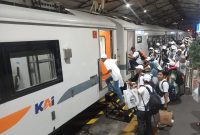 Para peserta mudik gratis yang diselenggarakan oleh PT INKA hendak memasuki Kereta Wijayakusuma dari Stasiun Madiun dengan tujuan akhir Ketapang, Banyuwangi, Kamis malam, 27 Maret 2025. Foto: Ofi/neumedia