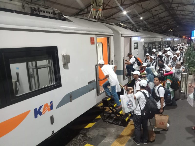Para peserta mudik gratis yang diselenggarakan oleh PT INKA hendak memasuki Kereta Wijayakusuma dari Stasiun Madiun dengan tujuan akhir Ketapang, Banyuwangi, Kamis malam, 27 Maret 2025. Foto: Ofi/neumedia