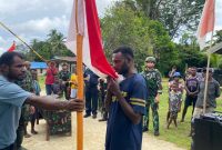 Anggota OPM yang kembali ke pangkuan NKRI mencium bendera Merah Putih. Foto : Yonif 501 Bajra Yudha