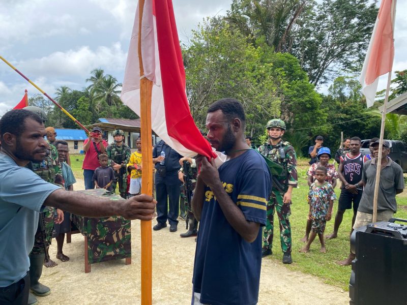Anggota OPM yang kembali ke pangkuan NKRI mencium bendera Merah Putih. Foto : Yonif 501 Bajra Yudha