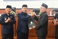 Penyerahan dokumen resmi dua Raperda yang disepakati oleh Ketua DPRD Kabupaten Madiun (kanan) kepada Bupati Madiun dalam sidang paripurna, Senin (7/7/2025) 
