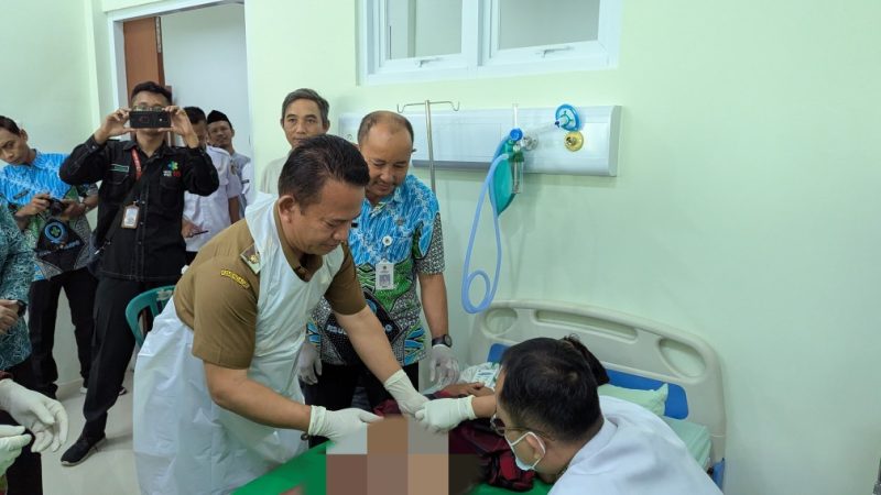 Wakil Bupati Madiun, dr. Purnomo Hadi terjun langsung menyunat salah satu peserta Khitan massal di RSUD Dolopo. 