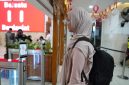 Seorang calon penumpang KA sedang di scan pengenalan wajah untuk percepat boarding penumpang di stasiun Madiun. 