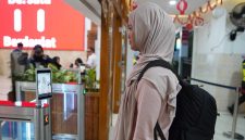 Seorang calon penumpang KA sedang di scan pengenalan wajah untuk percepat boarding penumpang di stasiun Madiun. 