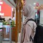 Seorang calon penumpang KA sedang di scan pengenalan wajah untuk percepat boarding penumpang di stasiun Madiun. 