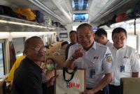 Vice President Daop 7 Madiun, Suharjono, membagikan souvenir kepada pelanggan kereta api. Foto : Humas Daop 7 Madiun