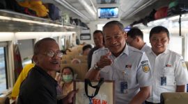 Vice President Daop 7 Madiun, Suharjono, membagikan souvenir kepada pelanggan kereta api. Foto : Humas Daop 7 Madiun
