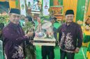Bupati Madiun H. Hari Wuryanto (kiri) dan Wakil Bupati dr. Purnomo Hadi menyerahkan sejumlah bantuan salah satunya peralatan Linmas saat Sarasehan BST Desa Nampu, Kecamatan Gemarang, Selasa malam (14/10/2025) 