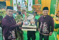 Bupati Madiun H. Hari Wuryanto (kiri) dan Wakil Bupati dr. Purnomo Hadi menyerahkan sejumlah bantuan salah satunya peralatan Linmas saat Sarasehan BST Desa Nampu, Kecamatan Gemarang, Selasa malam (14/10/2025)