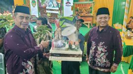 Bupati Madiun H. Hari Wuryanto (kiri) dan Wakil Bupati dr. Purnomo Hadi menyerahkan sejumlah bantuan salah satunya peralatan Linmas saat Sarasehan BST Desa Nampu, Kecamatan Gemarang, Selasa malam (14/10/2025) 