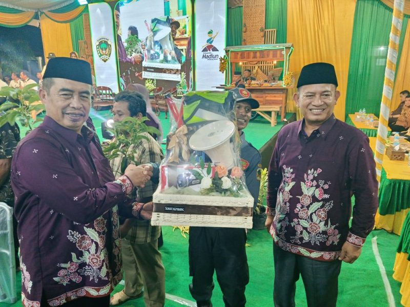 Bupati Madiun H. Hari Wuryanto (kiri) dan Wakil Bupati dr. Purnomo Hadi menyerahkan sejumlah bantuan salah satunya peralatan Linmas saat Sarasehan BST Desa Nampu, Kecamatan Gemarang, Selasa malam (14/10/2025) 