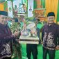 Bupati Madiun H. Hari Wuryanto (kiri) dan Wakil Bupati dr. Purnomo Hadi menyerahkan sejumlah bantuan salah satunya peralatan Linmas saat Sarasehan BST Desa Nampu, Kecamatan Gemarang, Selasa malam (14/10/2025) 