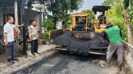 Anggota fraksi PDI Perjuangan DPRD Kabupaten Madiun, Budi Wahono (baju putih) didampingi Kades Bacem Muslih meninjau lokasi pekerjaan pengaspalan jalan hotmix, Kamis (23/10/2025)