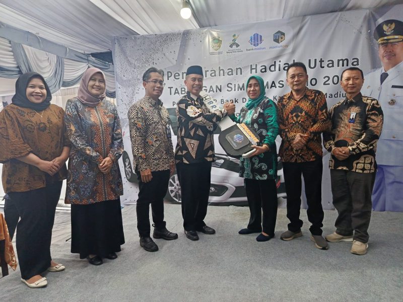 Bupati Madiun Hari Wuryanto secara simbolis menyerahkan hadiah satu unit mobil Honda Brio kepada Winarni, nasabah pemenang program Simarmas Brio BPR Kabupaten Madiun, Jumat (21/11/2025). 