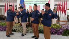 Bupati Madiun Hari Wuryanto menyerahkan pataka kepada Ketua Karang Taruna Kabupaten Madiun periode 2025-2030.