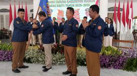 Bupati Madiun Hari Wuryanto menyerahkan pataka kepada Ketua Karang Taruna Kabupaten Madiun periode 2025-2030.