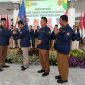 Bupati Madiun Hari Wuryanto menyerahkan pataka kepada Ketua Karang Taruna Kabupaten Madiun periode 2025-2030.