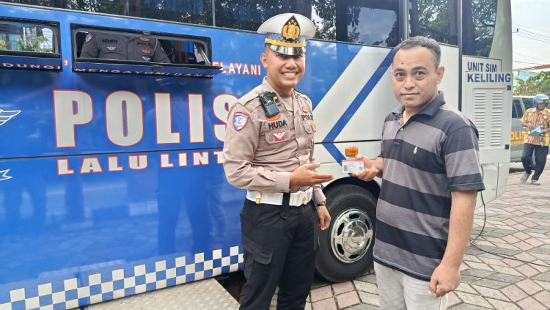 Salah seorang warga Kabupaten Madiun menunjukkan SIM barunya setelah memanfaatkan layanan SIGAPP Polres Madiun di Taman Asti Caruban, Kamis (15/1/2026). 