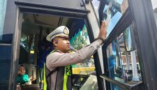 Kasat Lantas Polres Madiun, AKP Andrian Permana menempelkan stiker di sebuah bus yang sudah lolos RAM Check di terminal Caruban, Rabu (11/2/2026). 