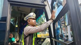 Kasat Lantas Polres Madiun, AKP Andrian Permana menempelkan stiker di sebuah bus yang sudah lolos RAM Check di terminal Caruban, Rabu (11/2/2026). 
