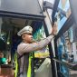 Kasat Lantas Polres Madiun, AKP Andrian Permana menempelkan stiker di sebuah bus yang sudah lolos RAM Check di terminal Caruban, Rabu (11/2/2026). 