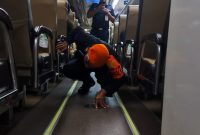Petugas KAI menyisir keberadaan ular cincin emas di dalam KA Kertanegara. Foto : istimewa
