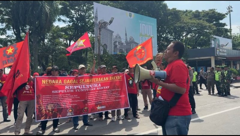 Ketua SBMR, Aris Budiono berorasi saat unjuk rasa May Day di Alun-alun Kota Madiun, Jumat (1/5/2026) 