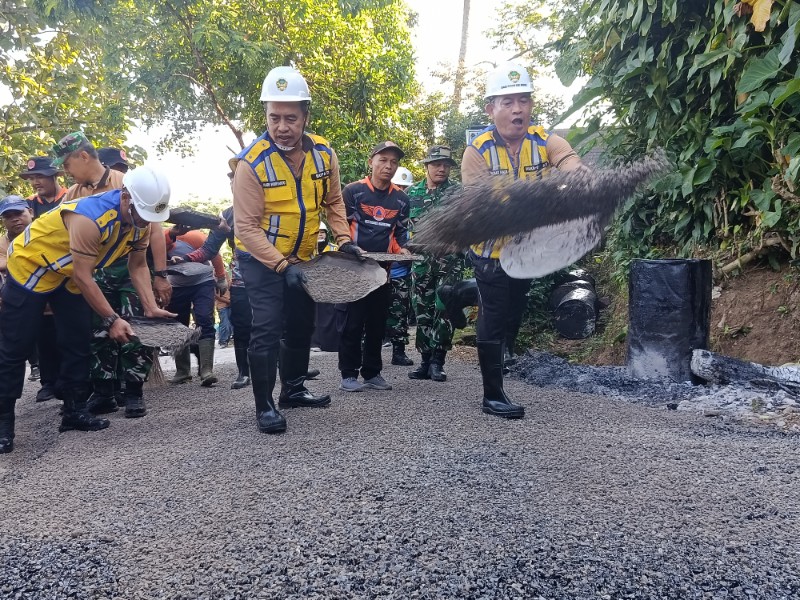 Kerja bakti pengaspalan jalan di Desa Bodag sebagai upaya Pemkab Madiun mendongkrak perekonomian masyarakat. 