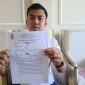 Siroojul Kahfi, owner PT Kahfi Indo Group, menunjukkan surat pengunduran diri AYF dari perusahaan miliknya. 