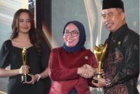 Wakil Menteri Koperasi RI, Farida Farichah (tengah) menyerahkan penghargaan kepada Bupati Madiun Hari Wuryanto. Foto : Istimewa
