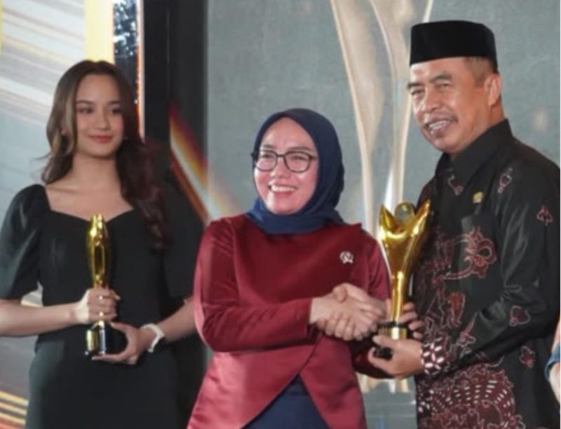 Wakil Menteri Koperasi RI, Farida Farichah (tengah) menyerahkan penghargaan kepada Bupati Madiun Hari Wuryanto. Foto : Istimewa